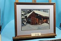Framed winter log cabin photograph on stand showing image, mat, and frame