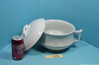 Overall view of chamber pot with lid and can for scale