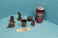 Group view with Dr Pepper can for scale showing all six miniature brass objects
