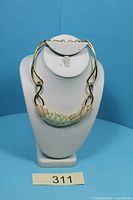Front view of Monet enamel water lily collar necklace displayed on stand