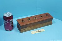 Block with cylinders inserted, soda can for scale