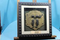 Framed oriental door hardware on easel, full view
