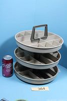 Full view of three-tier rotating tray beside soda can for scale