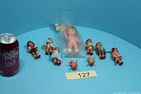 Group shot showing all dolls with can for scale