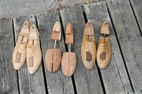 All three pairs of wooden shoe lasts laid out on boards