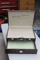 Display case open showing interior lining and pull-out drawer