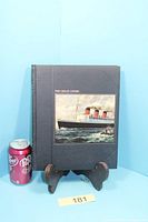 Front cover of the hardcover book beside a soda can for scale