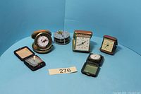 Overall view showing seven travel alarm clocks in various cases