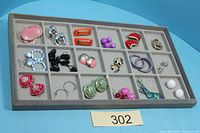 Full tray showing 18 pairs of assorted earrings