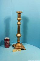 Full view of brass candlestick next to soda can for scale