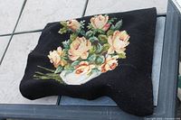 Needlepoint floral cushion cover on black background