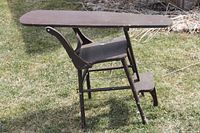 Side view showing chair converted to ironing board position