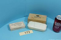 Group shot of crumb sweeper with box, Sandsteel mainspring box and scale can