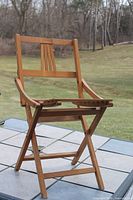 Full view of wooden folding armchair on patio table