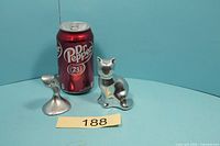 Cat and owl figurines beside soda can for scale