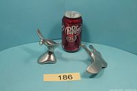 Both Hoselton aluminum goose sculptures beside a 355 mL soda can for scale