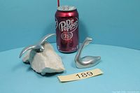 Both Hoselton sculptures beside soda can for scale