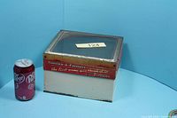 Front and side view showing tin next to soda can for scale