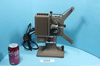 Front and side view of Kodak Kodascope Eight-71A projector beside soda can for scale