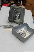 Projector rear with cover removed, cord visible