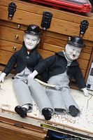 Both Laurel and Hardy porcelain dolls seated on table