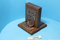 Oblique view of one bookend showing wood construction and metal McGill crest plaque