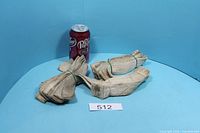 Three bundles of beige cotton oil lamp wicks next to soda can for scale, lot tag visible