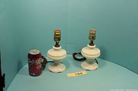 pair of small milk glass lamps beside soda can for scale