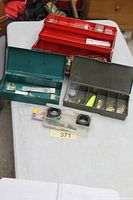 All three tackle boxes open with contents visible