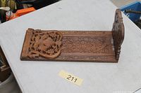 Full view of folded wooden book slide showing carvings and hinges