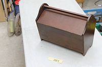Closed wooden sewing box on table