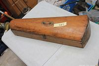 Closed wooden violin case top view showing hardware and wear