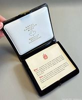 Open presentation case showing satin lid logo and certificate card