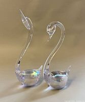 Front view of both clear iridescent glass swan figurines