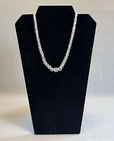 Full view of necklace on black display bust highlighting overall length and bead uniformity