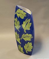 Front view showing blue glaze and green leaf motifs