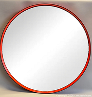 front view showing circular mirror and red steel rim