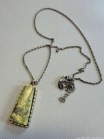Necklace laid flat showing full chain, pendant front, and clasp