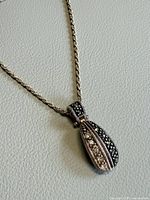 Close-up of pendant on chain showing marcasite and white stones