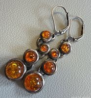 Front view of both earrings showing amber stones and silver setting