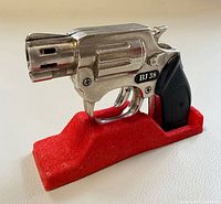 Left side view of BJ 38 gas lighter on red stand