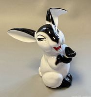 Front left view of black and white glossy porcelain bunny