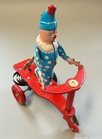 Left side view showing clown figure, handlebar, rear coil spring and key