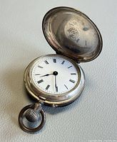 Pocket watch open showing dial and inner cover
