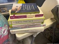 Stack of six parenting and childbirth books showing spines
