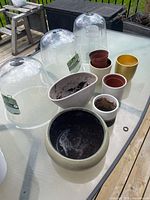 All six planters and three cloches on glass table