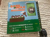 Front of sealed Bark A Mole playset box with window showing one plush mole