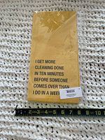 Front view of packaged folded yellow dish towel with printed humorous text and tape measure showing about 15 inches