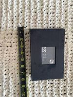 Closed black 100-capacity photo album beside tape measure