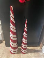 Two different height candy cane striped Styrofoam cones standing upright
